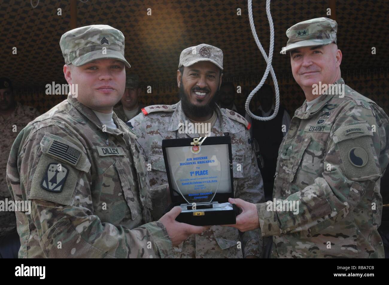 Sgt. Brian Dilley, a squad leader with the 69th Air Defense Artillery Brigade, accepts the First Place award on behalf of his unit from Major General Blake Ortner, Commander of the 29th Infantry Division and Col. Jabar Al-boti of the Kuwaiti Air Defense Force during Patriot Day activities at Kuwaiti Air Defense Force Headquarters in Kuwait December 28, 2016. The friendly competition between the Kuwaitis and the 69th ADA included events such as setting up an MIM-104 Patriot weapons system, a soccer game, and tug-of-war. ( Stock Photo