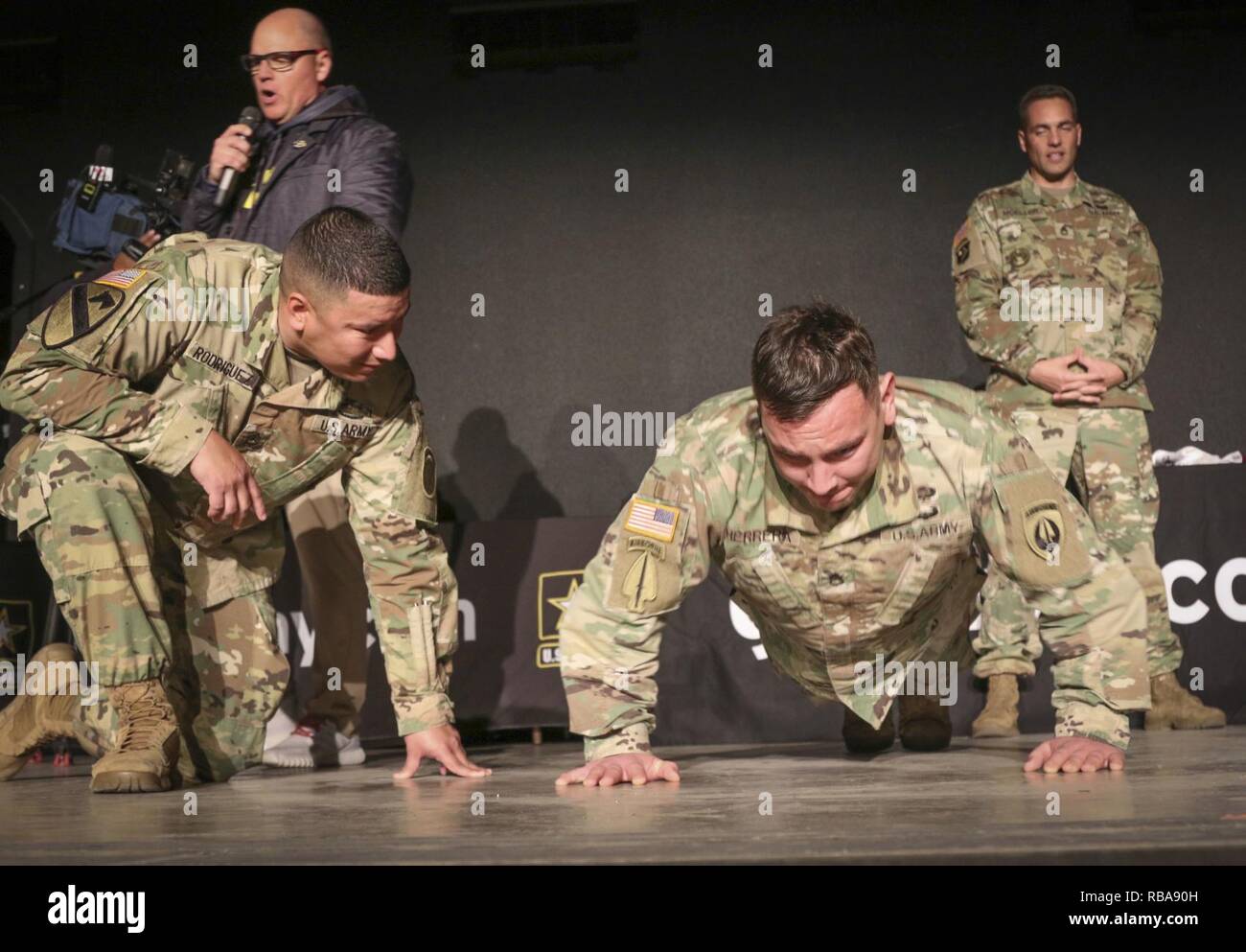Army Staff Sgt. Rodrigo Rodriguez (Left), a recruiter assigned to the 5th Recruiting Brigade, counts push-ups for Army Staff Sgt. Rene P. Herrera, a Chemical, Biological, Radiological, and Nuclear specialist and a Soldier mentor for the U.S. Army All-American Bowl, assigned to the 160th Special Operations Aviation Regiment during a push-up challenge pitting East versus West high-school football players and band members against each other in friendly competition.  The Soldiers got into the action, not only judging the competition, but joining the teams in the event as well.  For 16 years the U. Stock Photo