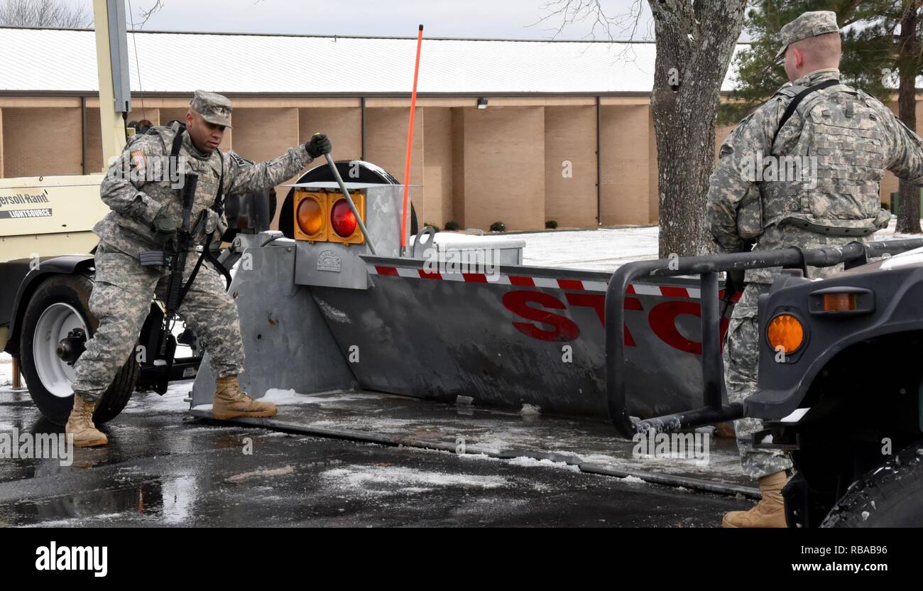 Sgt. William Clarke (left) and Spec. Johnathon Christensen (right), Military Police Officers assigned to the 216th Military Police Company, 871st Troop Command Battalion, 87th Troop Command Brigade, Arkansas National Guard, lower the gate at a security checkpoint for invited guests at the 2017 National Guard Senior Commanders Forum held at the Professional Education Center on Robinson Maneuver Training Center in North Little Rock, Arkansas, on Friday. Stock Photo