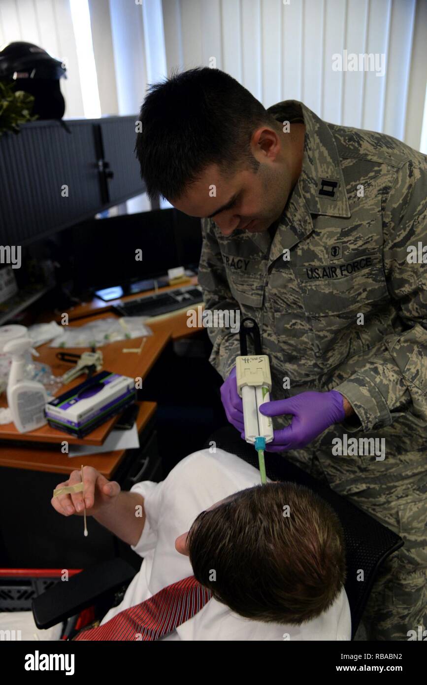 Capt. Christopher Tracy, 86th Dental Squadron dentist, applies molding material to the ear of an Air Force Office of Special Investigations agent at an OSI office at Ramstein Air Base, Germany, Jan. 6, 2017. Each mold took 10 to 15 minutes to become firm enough to remove. Stock Photo
