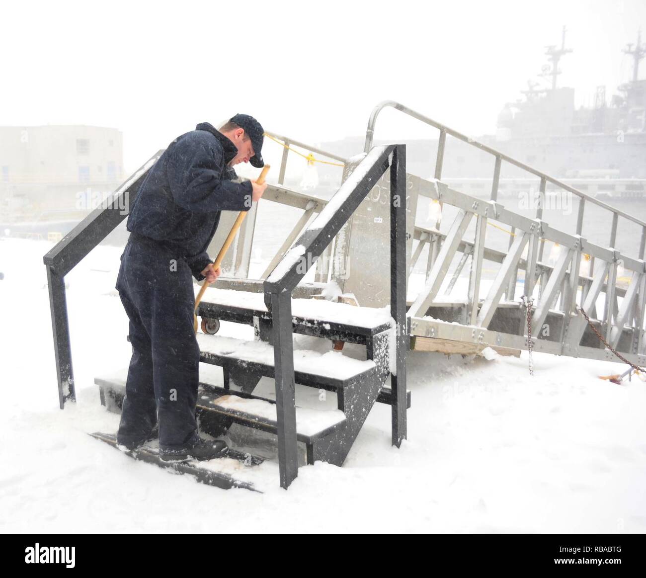 Aviation Boatswain's Mate (Launching and Recovery) 1st Class Cameron Owens sweeps snow off the