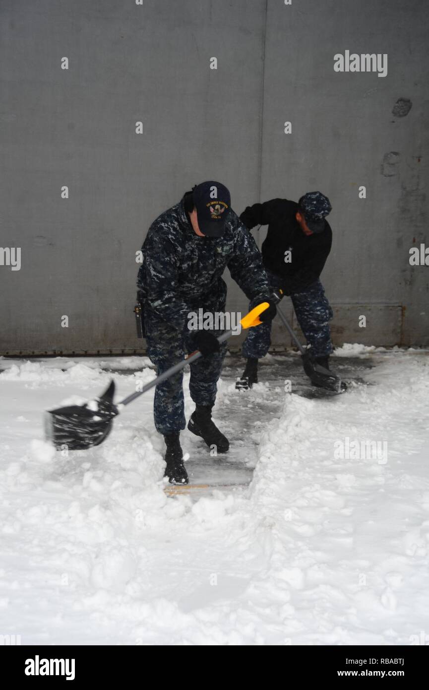 Aviation Boatswain's Mate (Launching and Recovery) Airman Zachery Pavey shovels snow aboard the