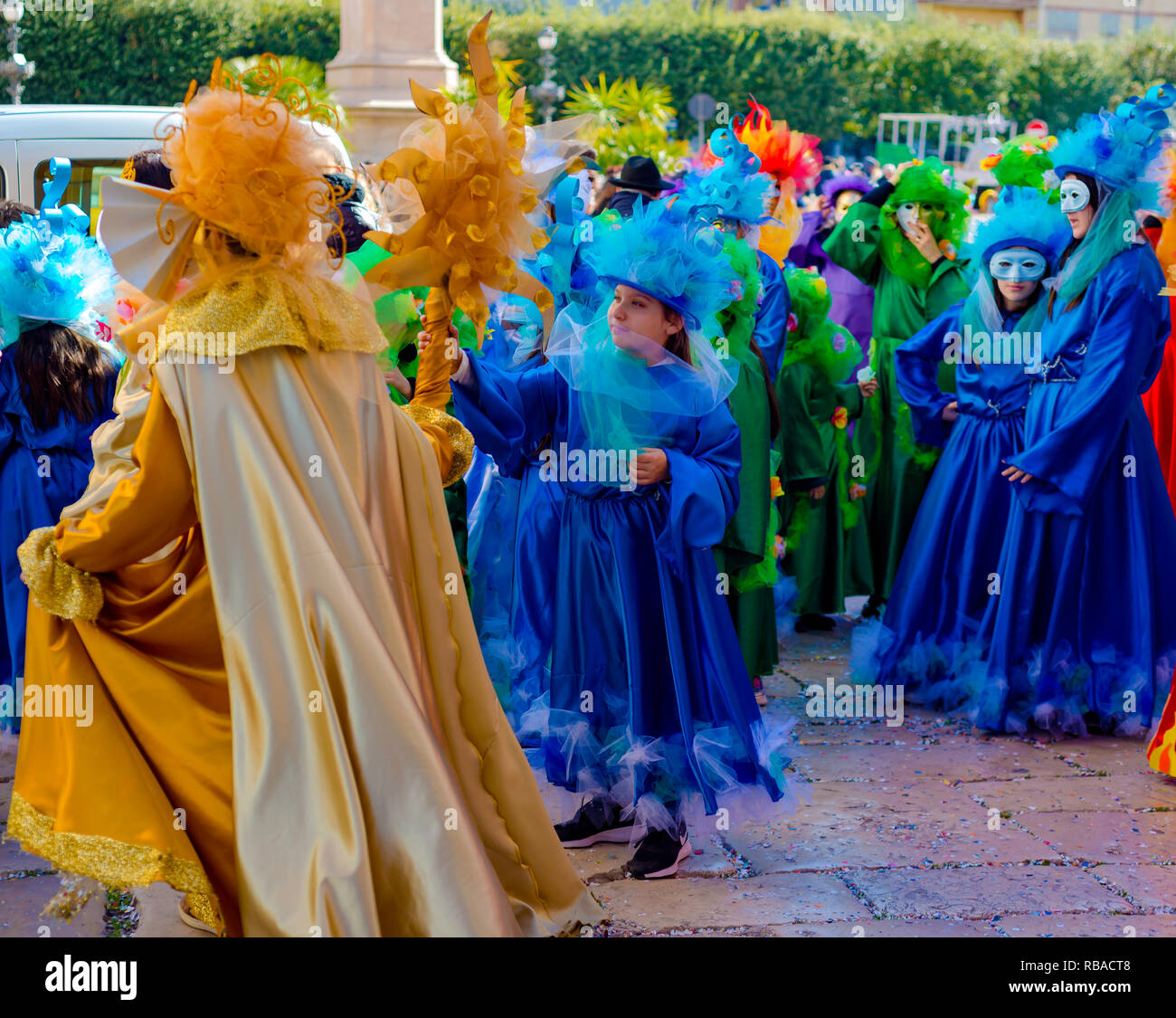 Modugno, Italy - February 4, 2018: Young people and children with beautiful and colorful clothes during the parade of masked groups in the city street Stock Photo