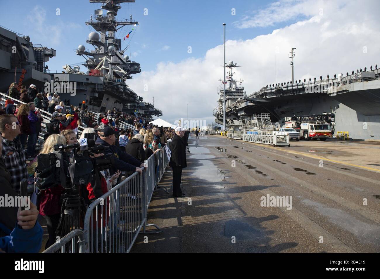 NORFOLK, Va. (Dec. 16, 2018) Sailors' families and friends wait on the pier during the Nimitz-class aircraft carrier USS Harry S. Truman (CVN 75) homecoming. Truman returns to Naval Station Norfolk following the Harry S. Truman Carrier Strike Group’s (HSTCSG) deployment in support of maritime security operations and theater security cooperation efforts in the U.S. 2nd, 5th and 6th Fleet areas of responsibility. Stock Photo