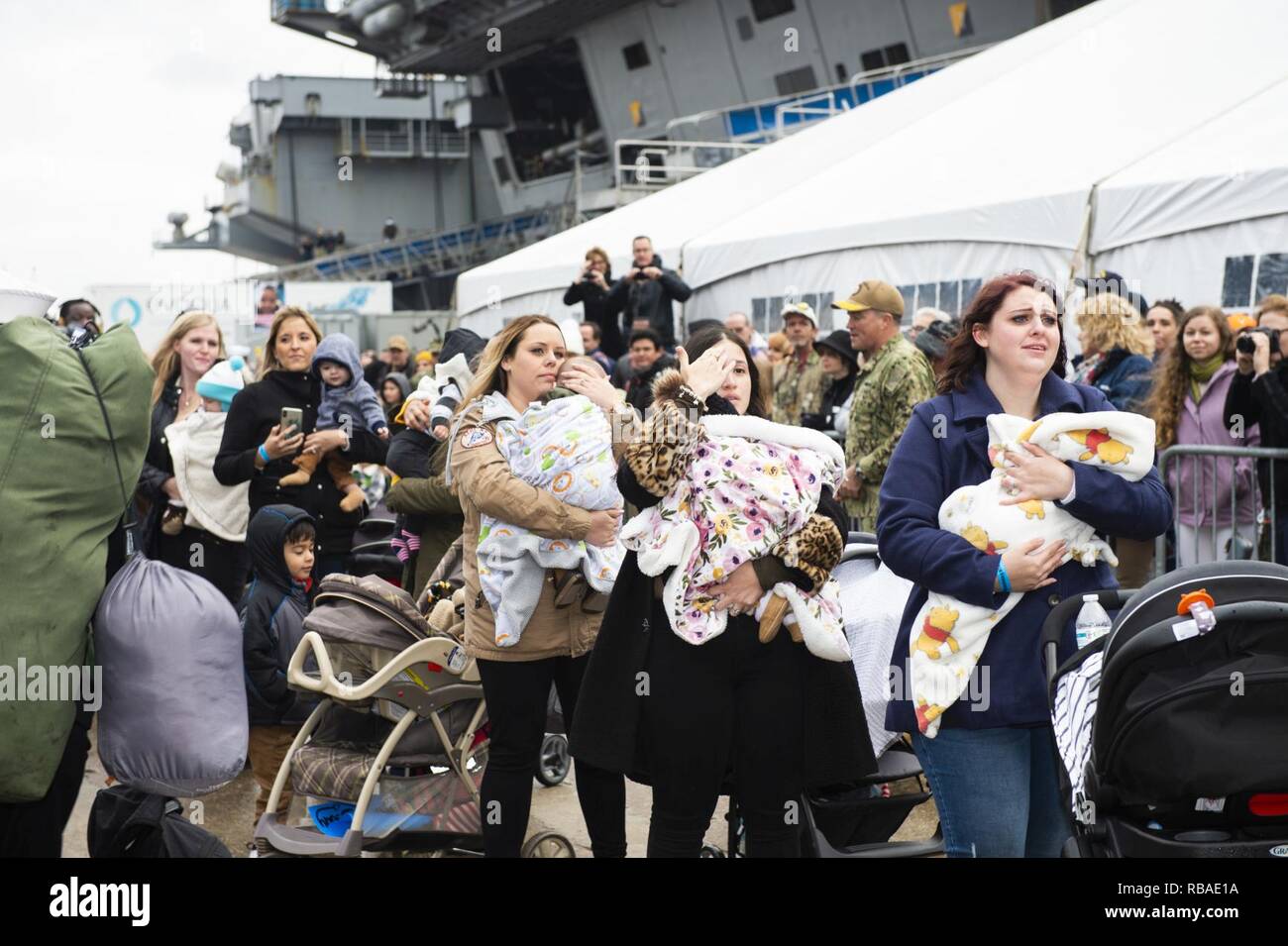 NORFOLK, Va. (Dec. 16, 2018) Families await the arrival of the Nimitz-class aircraft carrier USS Harry S. Truman (CVN 75) during the ship’s homecoming. Truman returns to Naval Station Norfolk following the Harry S. Truman Carrier Strike Group’s (HSTCSG) deployment in support of maritime security operations and theater security cooperation efforts in the U.S. 2nd, 5th and 6th Fleet areas of responsibility. Stock Photo