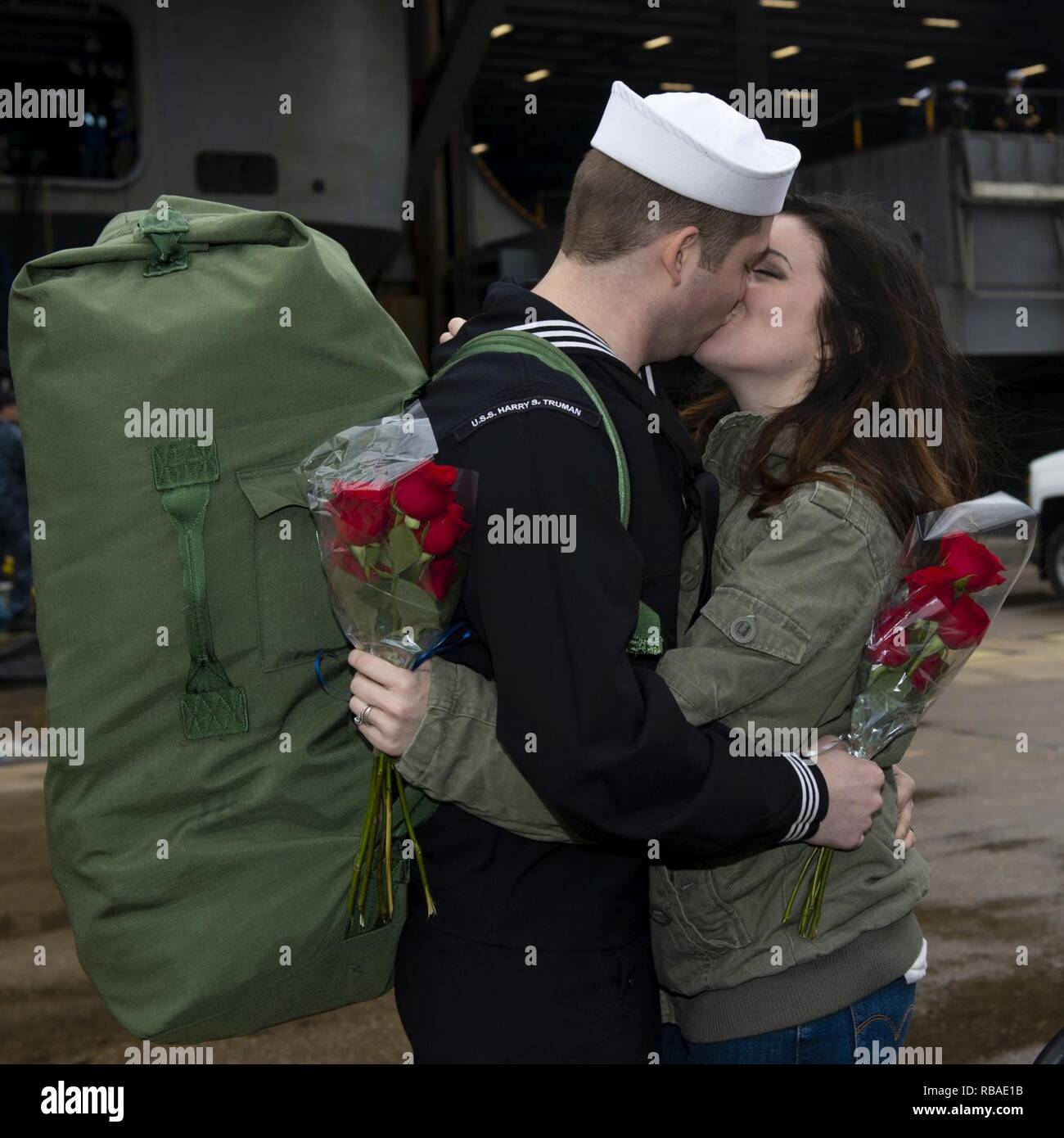 NORFOLK, Va. (Dec. 16, 2018) Logistics Specialist 2nd Class Wyatt Easter kisses his wife on the pier during the Nimitz-class aircraft carrier USS Harry S. Truman (CVN 75) homecoming. Truman returns to Naval Station Norfolk following the Harry S. Truman Carrier Strike Group’s (HSTCSG) deployment in support of maritime security operations and theater security cooperation efforts in the U.S. 2nd, 5th and 6th Fleet areas of responsibility. Stock Photo