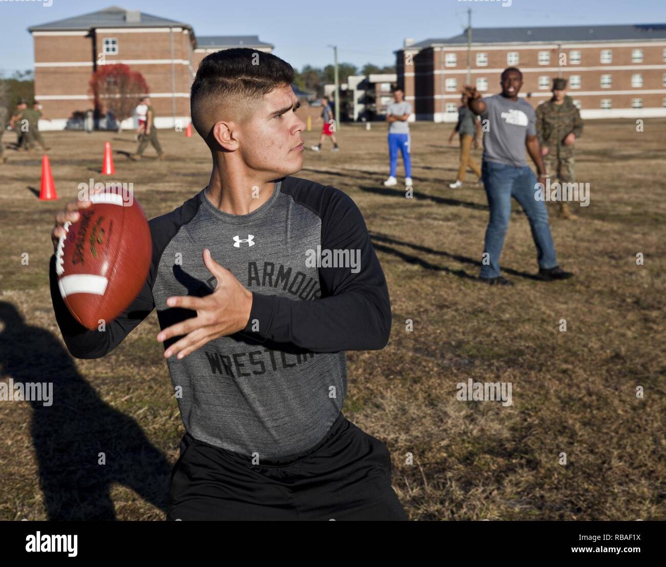 U.S. Marine Corps Pfc. Anthony Park, a student attending Personnel Administration School, Marine Corps Combat Service Support Schools, prepares to throw a football during the Holiday Bash at Camp Johnson N.C., Dec. 17, 2018. The Holiday Bash combined team-building exercises and holiday spirit activities to celebrate the past year, foster morale and esprit de corps, and to commemorate the holiday season for all Camp Johnson personnel. Stock Photo