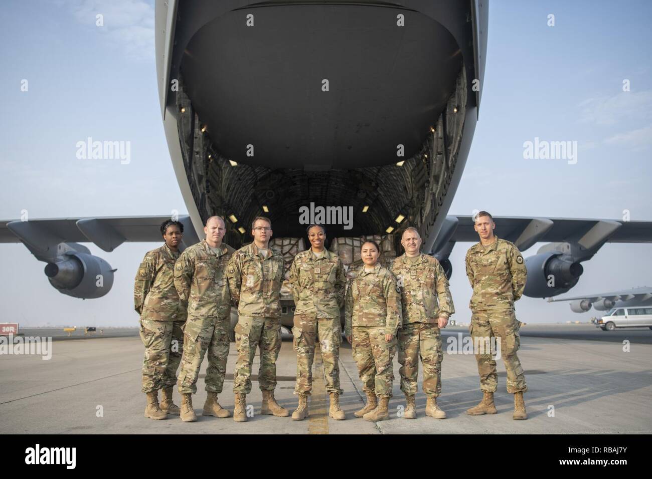 Members of the 386th Expeditionary Force Support Squadron Sustainment Services Flight, pose for a group photo in front of A C-17 Globemaster III loaded 14 aircraft pallets containing war reserve material at an undisclosed location in Southwest Asia, Dec. 20, 2018. The cargo, procured and coordinated by the flight, will support a mandated coalition exercise for the sustainment, morale, and training of 300 personnel. Stock Photo
