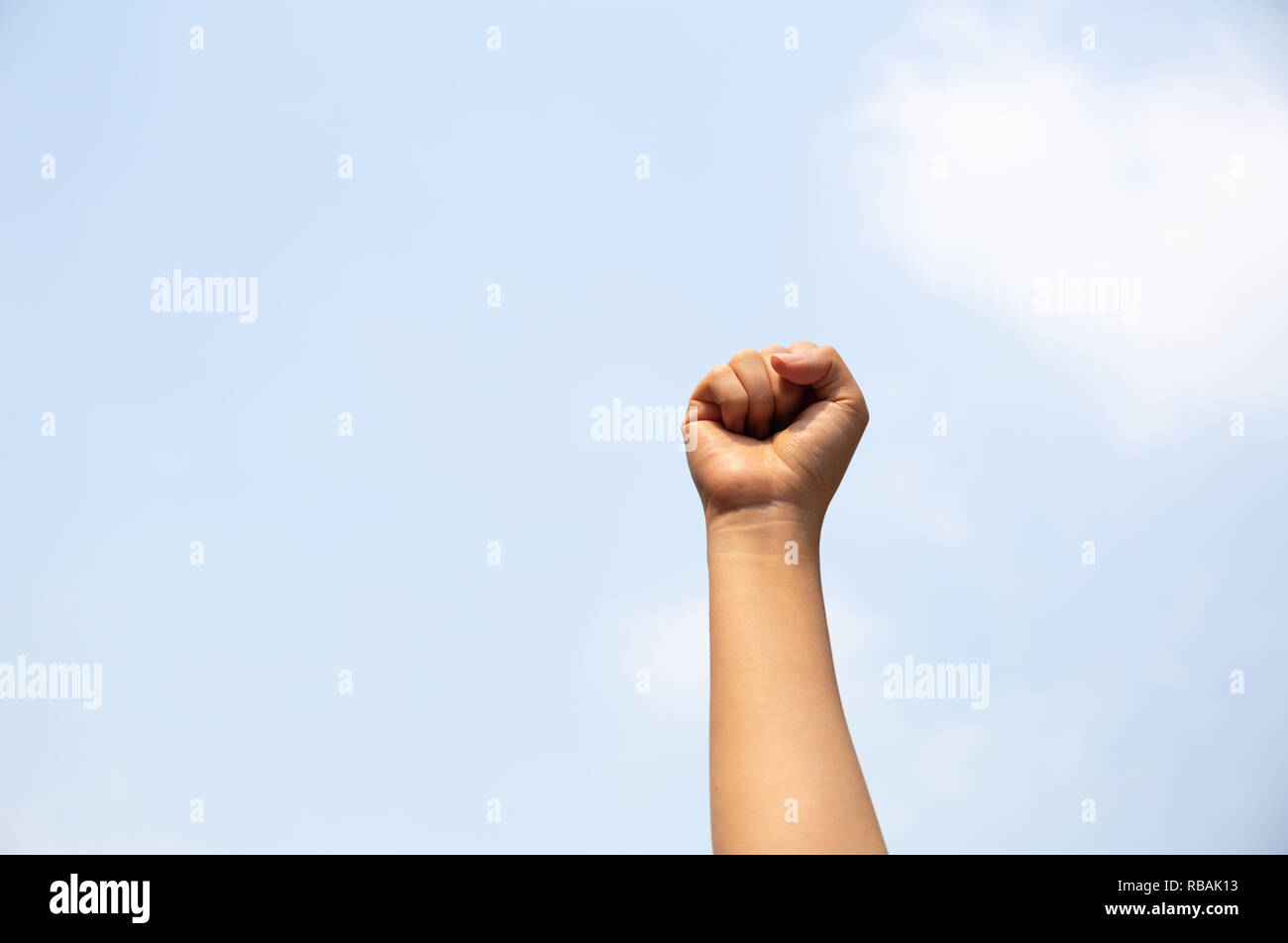 Woman arm with fist raised in the air. Stock Photo