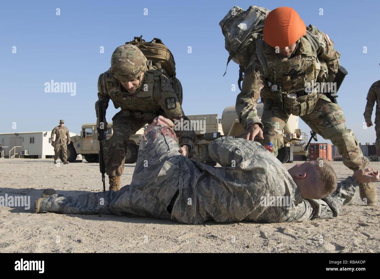U.S. Army combat medics Sgt. Michael B. Drozd, assigned to the 719th Medical Detachment Veterinary Services, left, and Sgt. Neal W. Cypriano, assigned to task Force Sinai, right, rush to treat a simulated casualty during a medical training scenario, Dec. 23, 2018, Camp Arifjan, Kuwait. U.S. Army Central combat medic Soldiers conduct regular training to maintain a high level of combat readiness and proficiency. Stock Photo