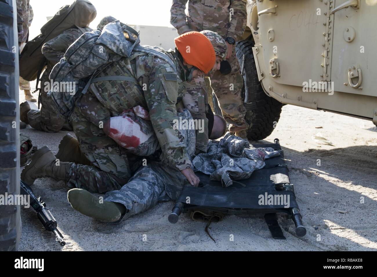 U.S. Army combat medics prepare to roll a simulated casualty onto a litter during a medical training scenario, Dec. 23, 2018, Camp Arifjan, Kuwait. The medics were being tested on various tasks to meet their ongoing training requirements as combat medics. Stock Photo