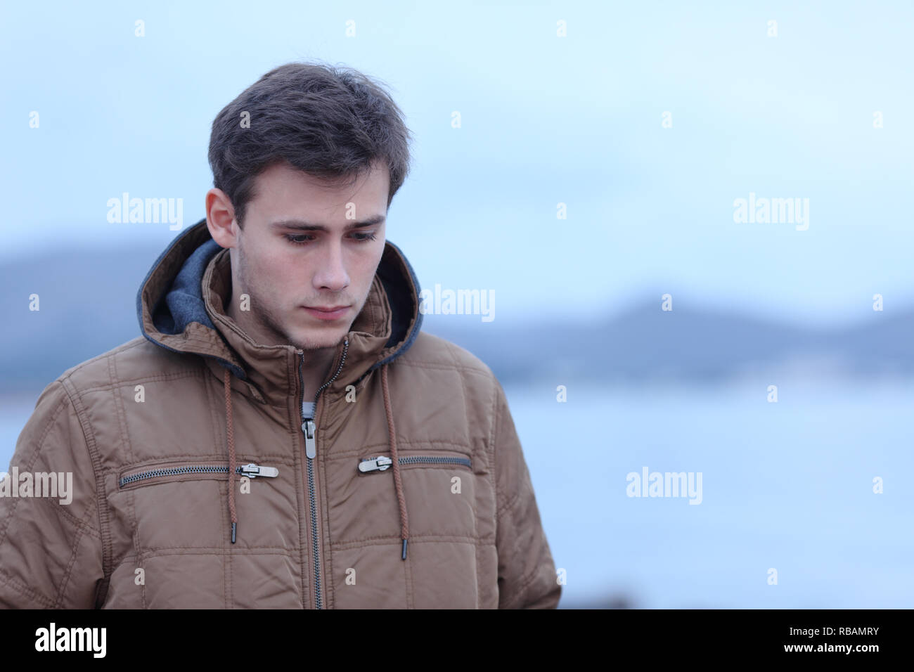 Sad man complaining walking alone on the beach in winter Stock Photo