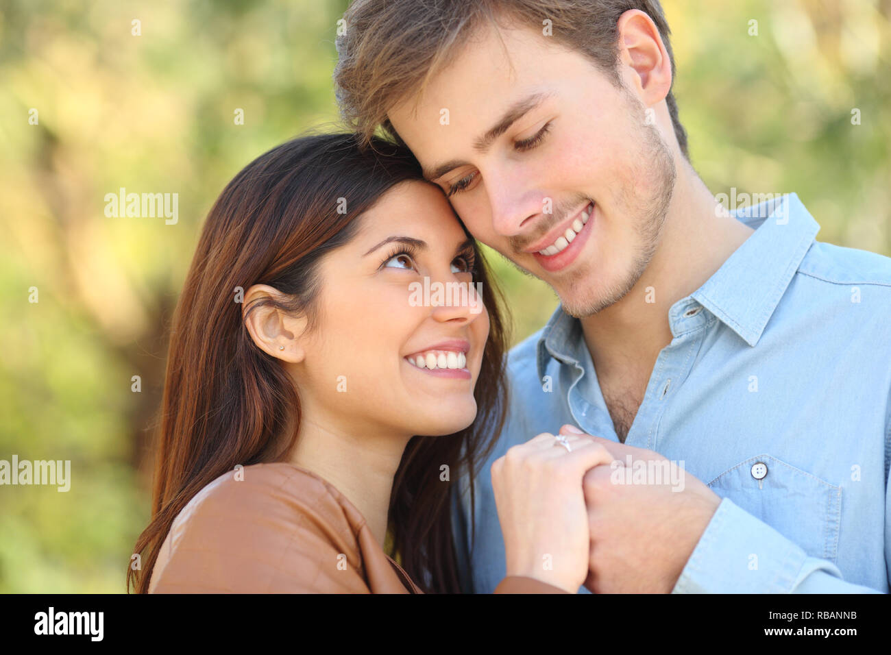 Happy couple in love looking each other holding hands standing in a park Stock Photo - Alamy