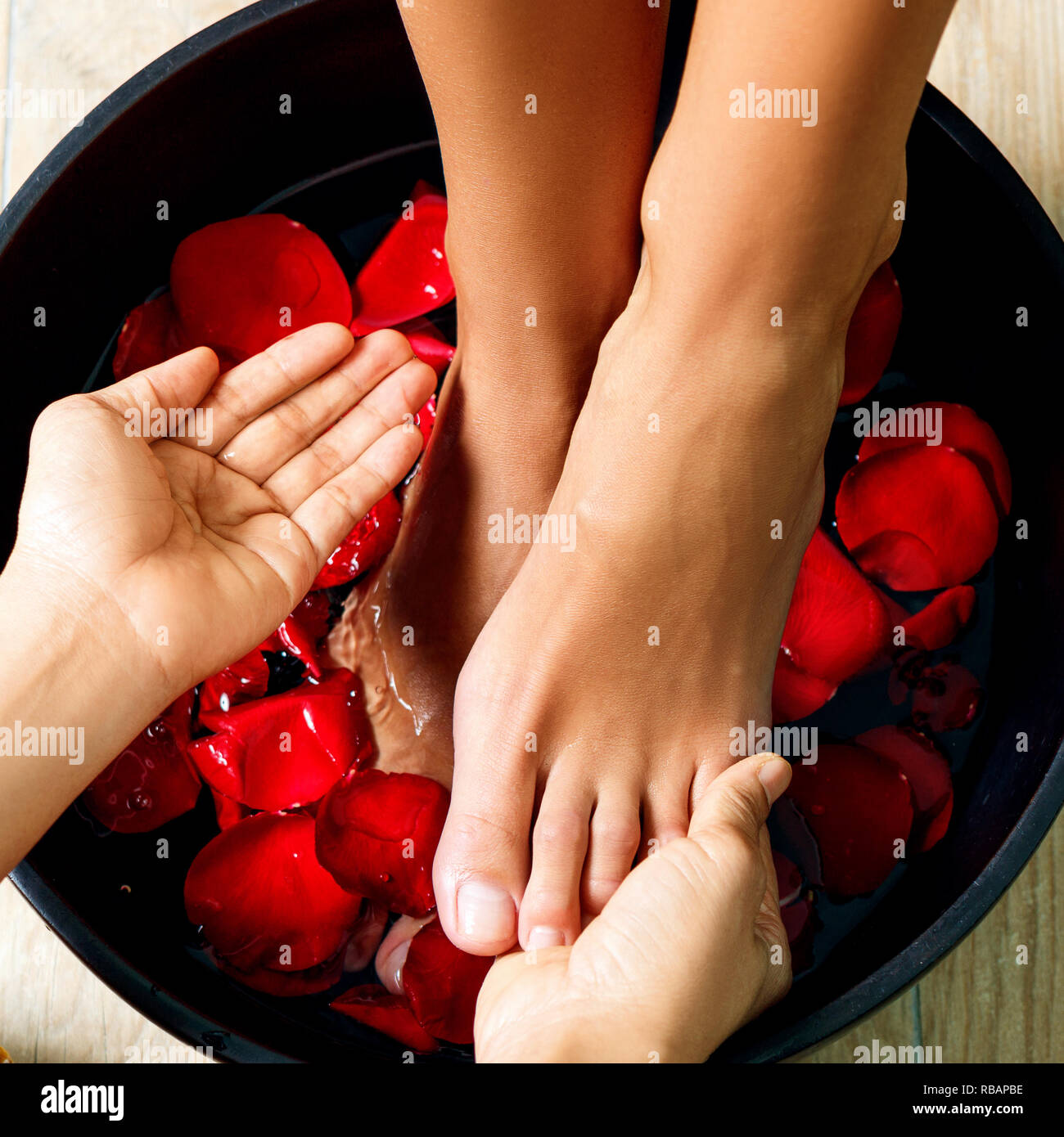 Foot washing in the spa salon. Legs massage concept. Feet spa Stock