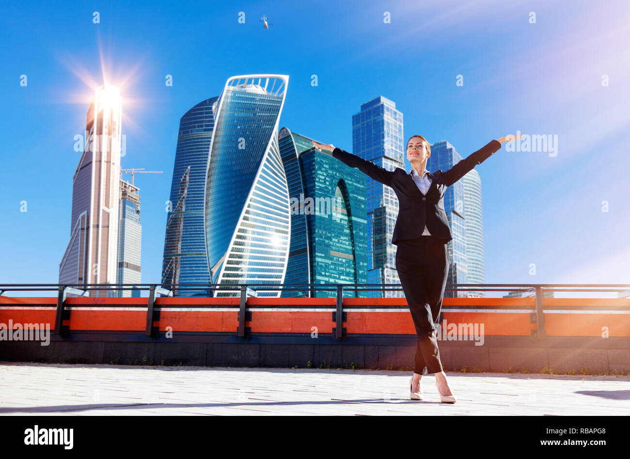 Business woman feels triumph on observation deck over Moscow city background. Stock Photo