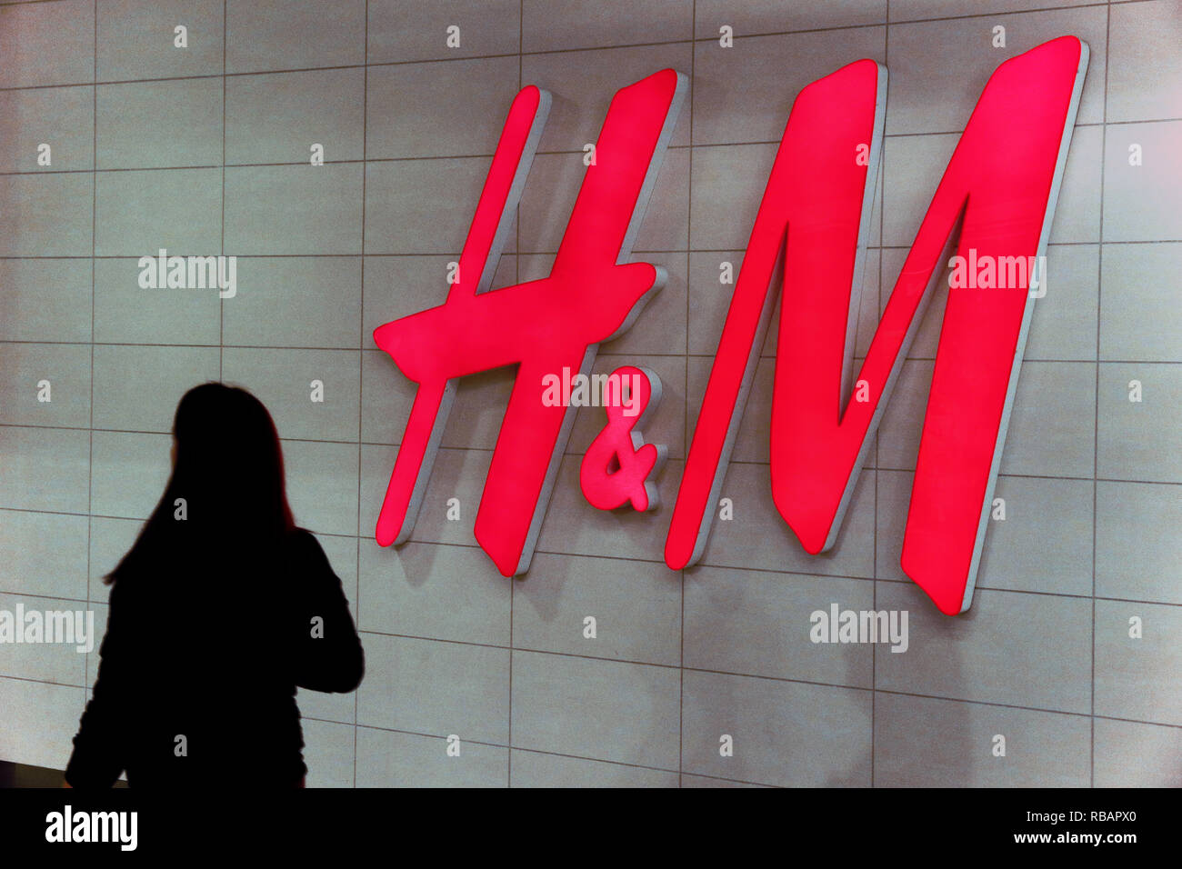 Logotype H M, swedish Hennes & Mauritz Brand at wall of store in clothing shop. A world wide clothes shop or clothes store. Stock Photo