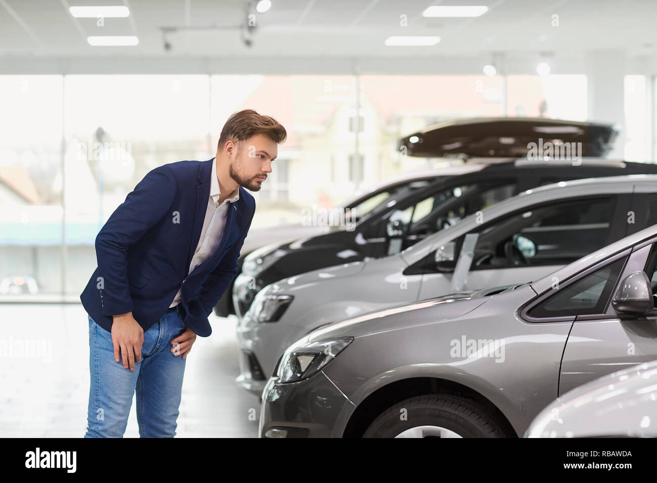 The buyer of the car thinks in the car dealership.  Stock Photo
