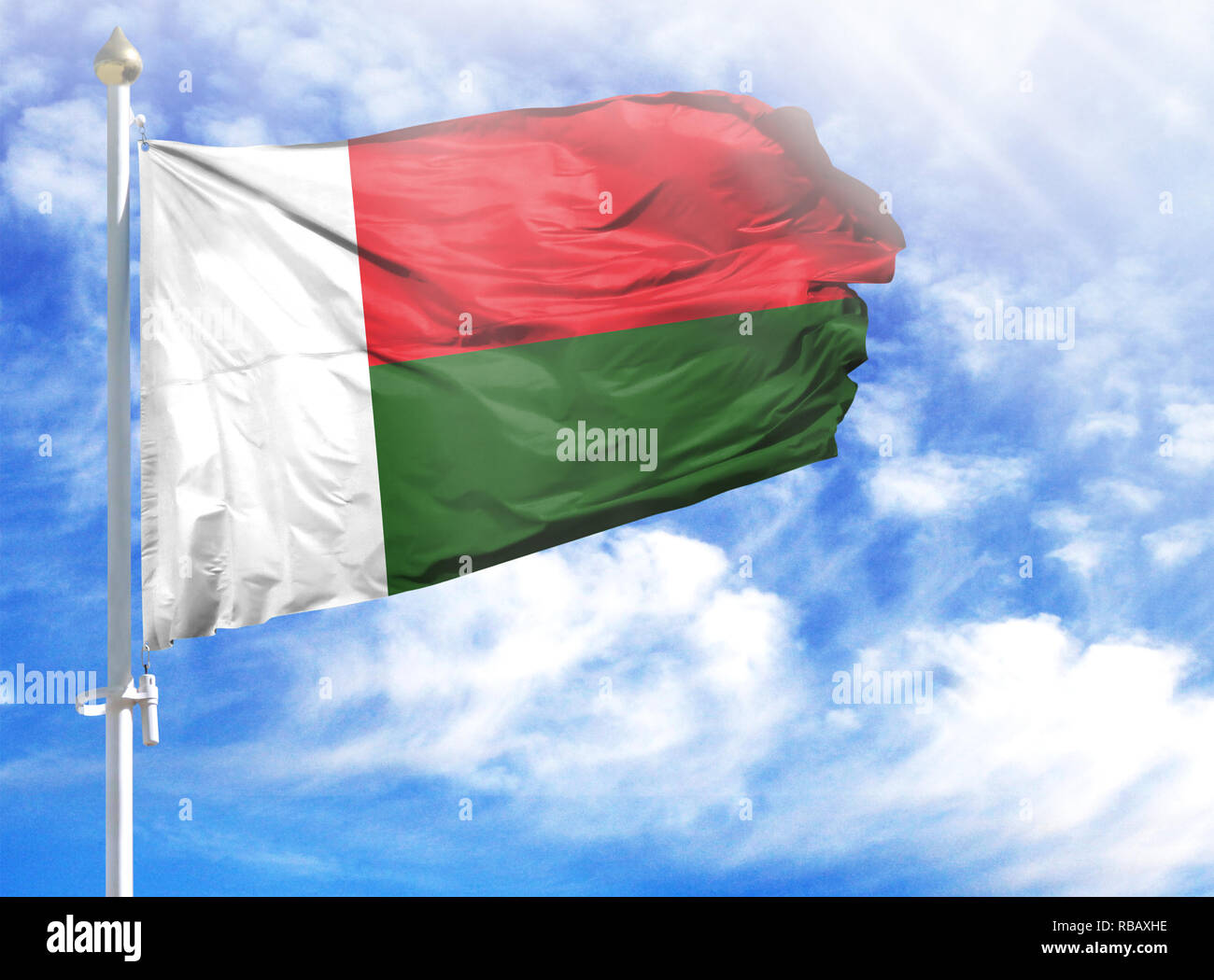 National flag of Madagascar on a flagpole in front of blue sky Stock ...