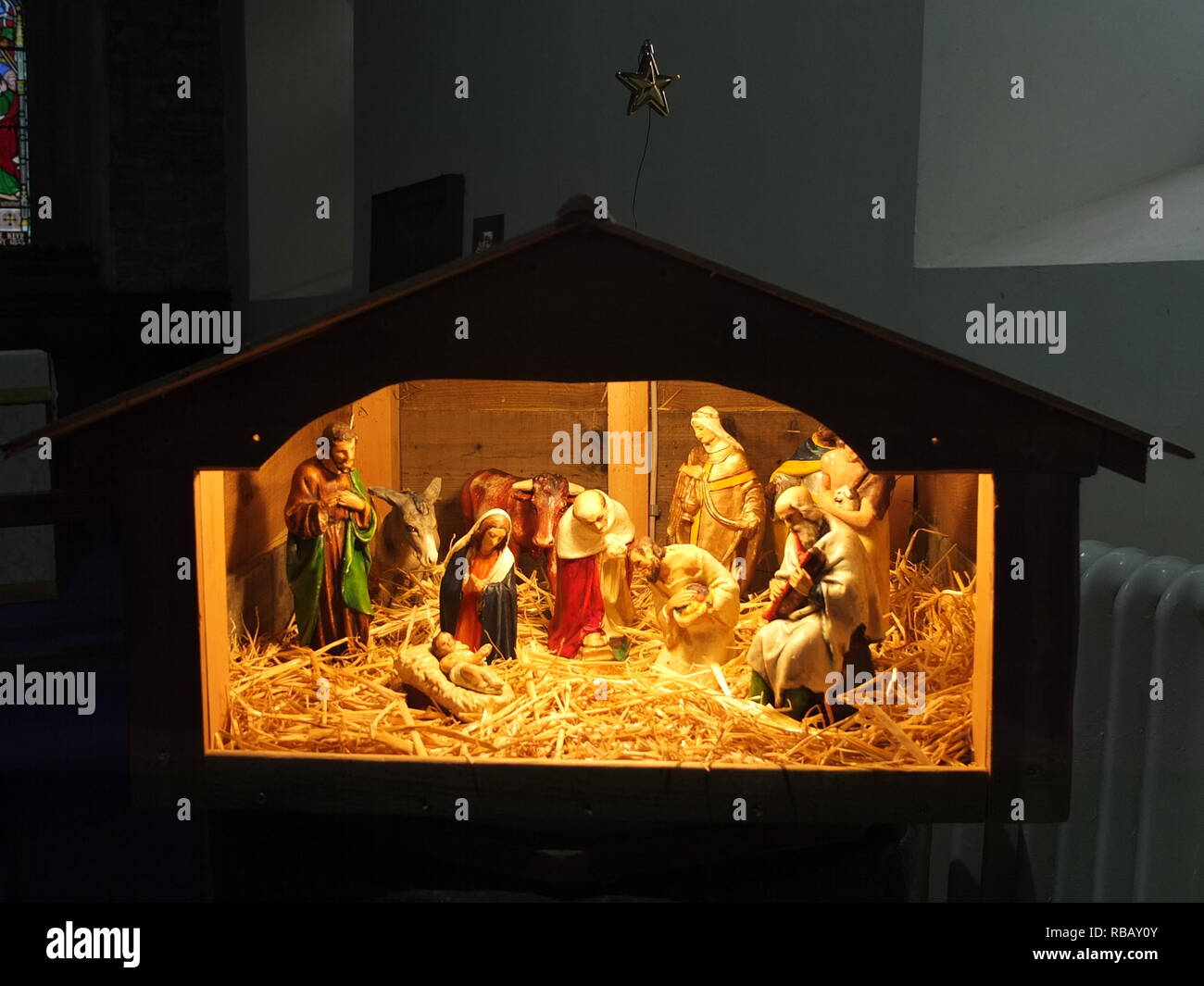 Illuminated crib nativity scene in a church for Christmas (St Edmunds Church, Castleton, Derbyshire, UK) Stock Photo