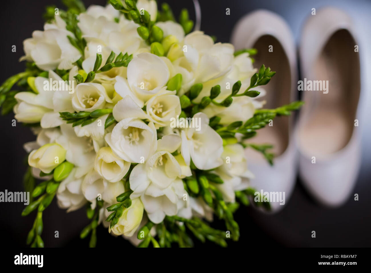 The wedding bouquet and bride shoes. Close up. Wedding background Stock