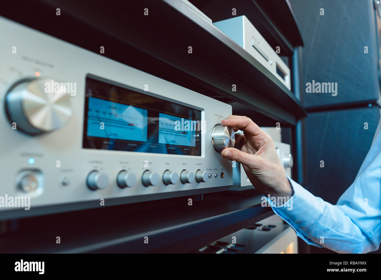 Hand of woman turning up volume of HiFi amplifier Stock Photo Alamy