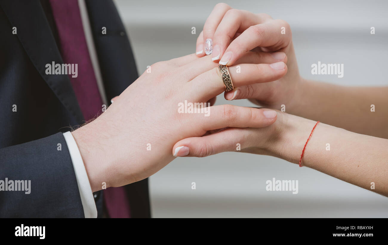 Bride putting a wedding ring on grooms finger Stock Photo Alamy