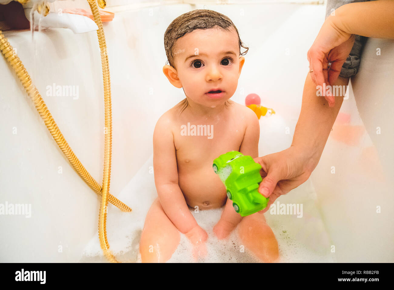 little baby child bathe play with toys in bath tub Stock Photo