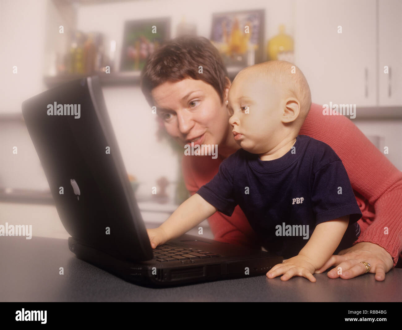 Mother and toddler son on a laptop computer enjoying screen time together Stock Photo