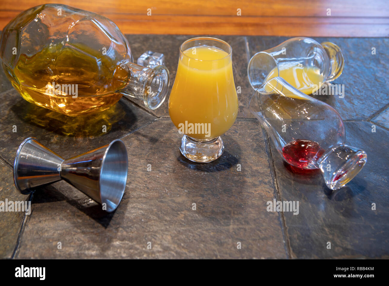 Ingredients for tequila sunrise including tequila bottle, orange juice