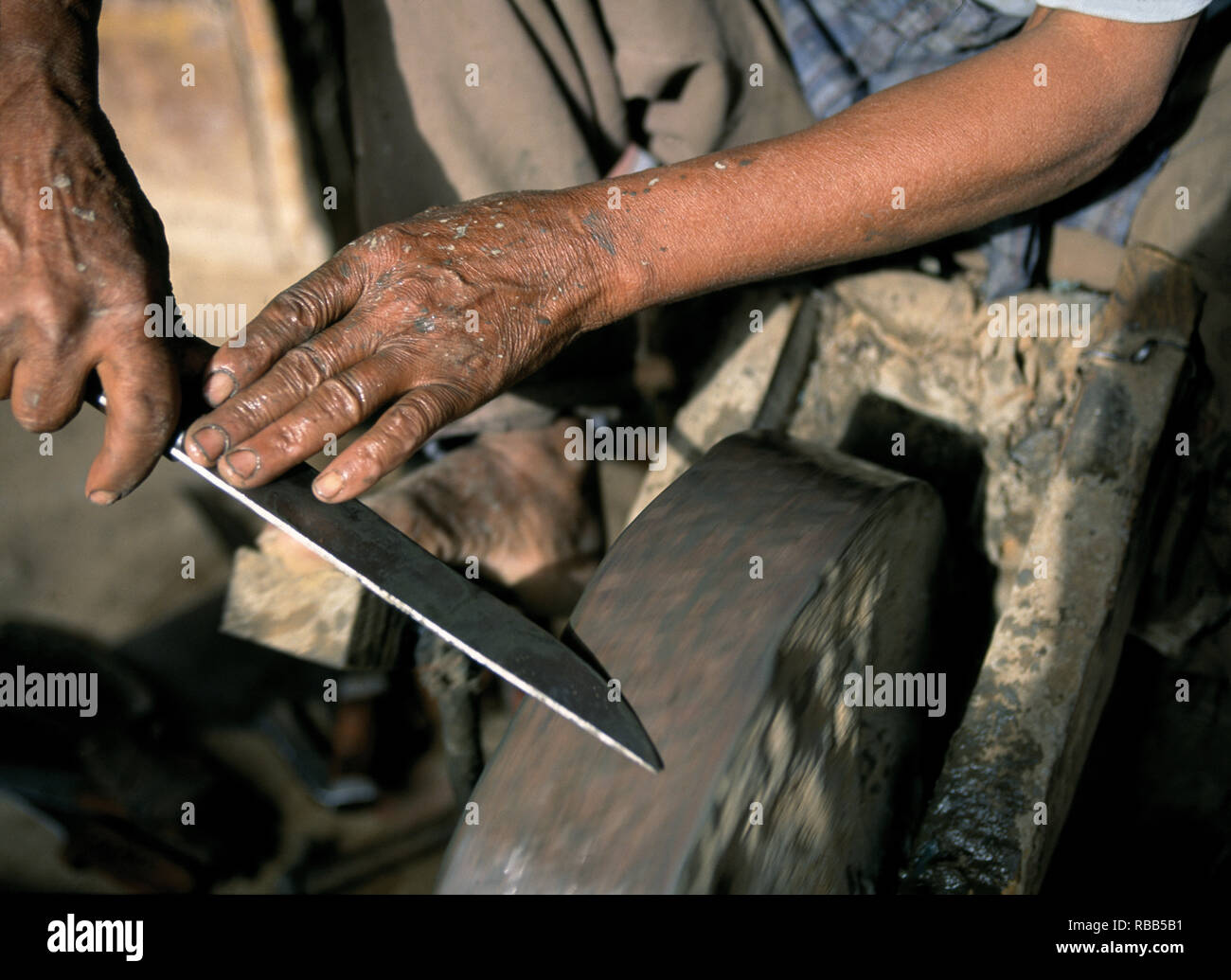 Man sharpening knife on spinning sharpening stone Stock Photo Alamy
