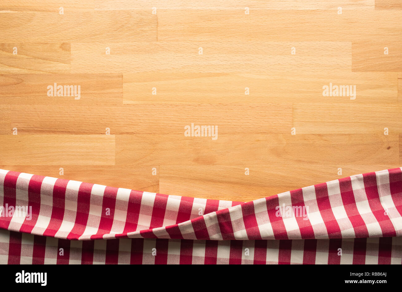 Red checkered fabric on wood table background.For decoration key visual