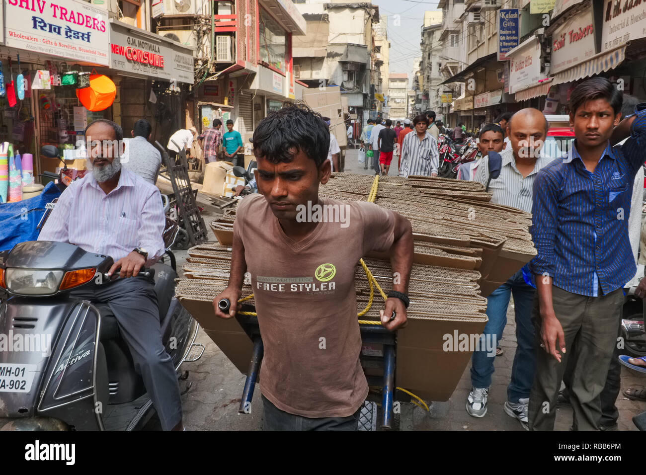 A handcart puller in Bhendi Bazar area, Mumbai, India, looking stressed, stuck in a traffic jam in a congested lane Stock Photo