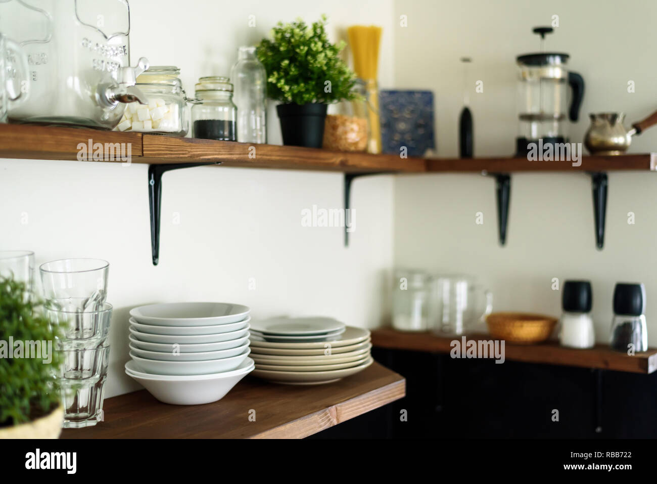 Dish And Decorations On Open Wooden Shelves In White Kitchen Stock