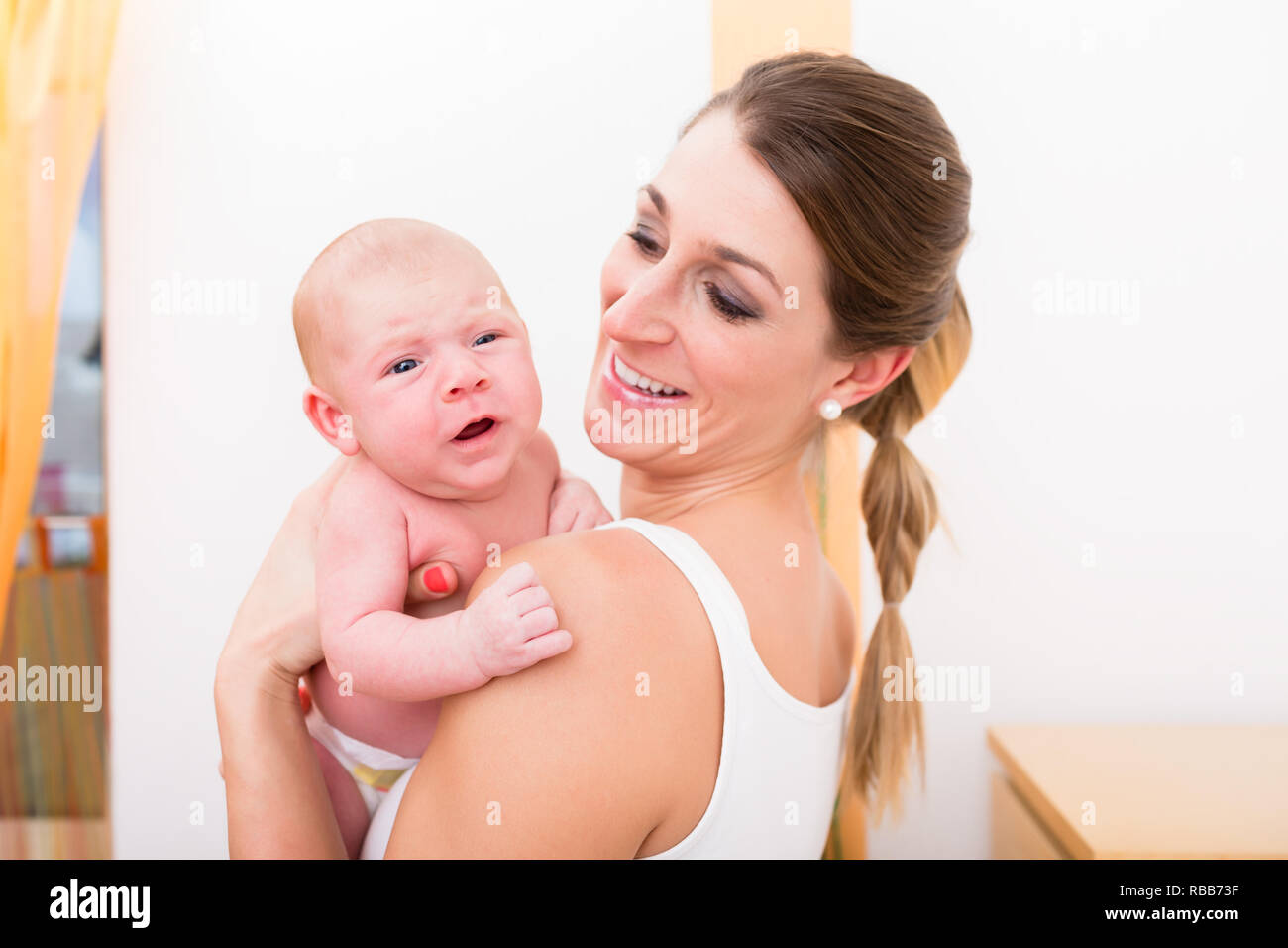 Mother carrying her newborn baby Stock Photo