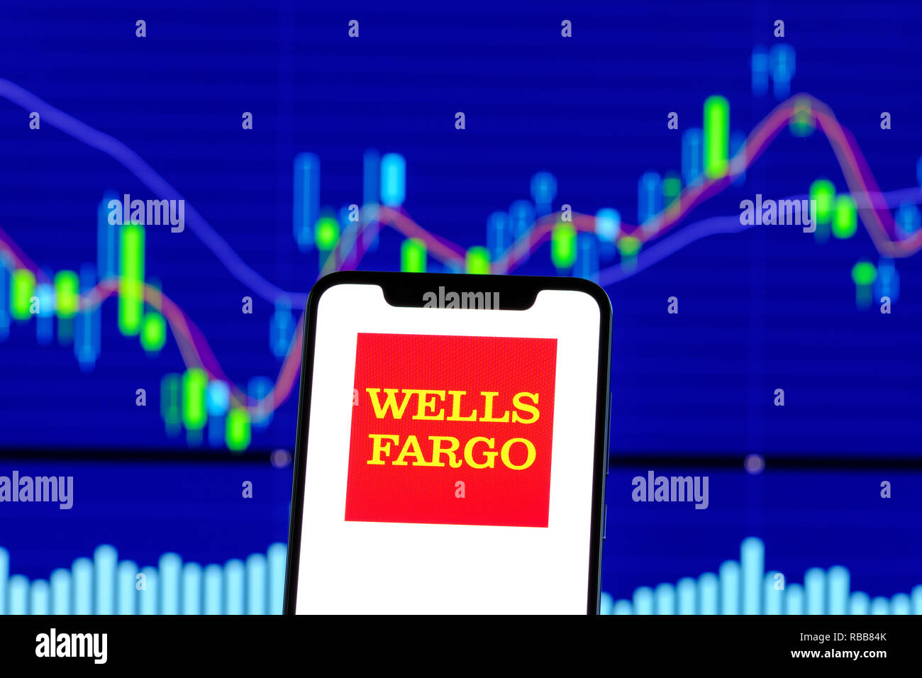Wells Fargo logo is seen on an smartphone over stock chart Stock Photo