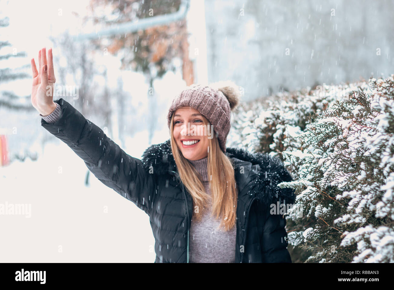 Portrait of beautiful woman in winter cloathes waving. Stock Photo