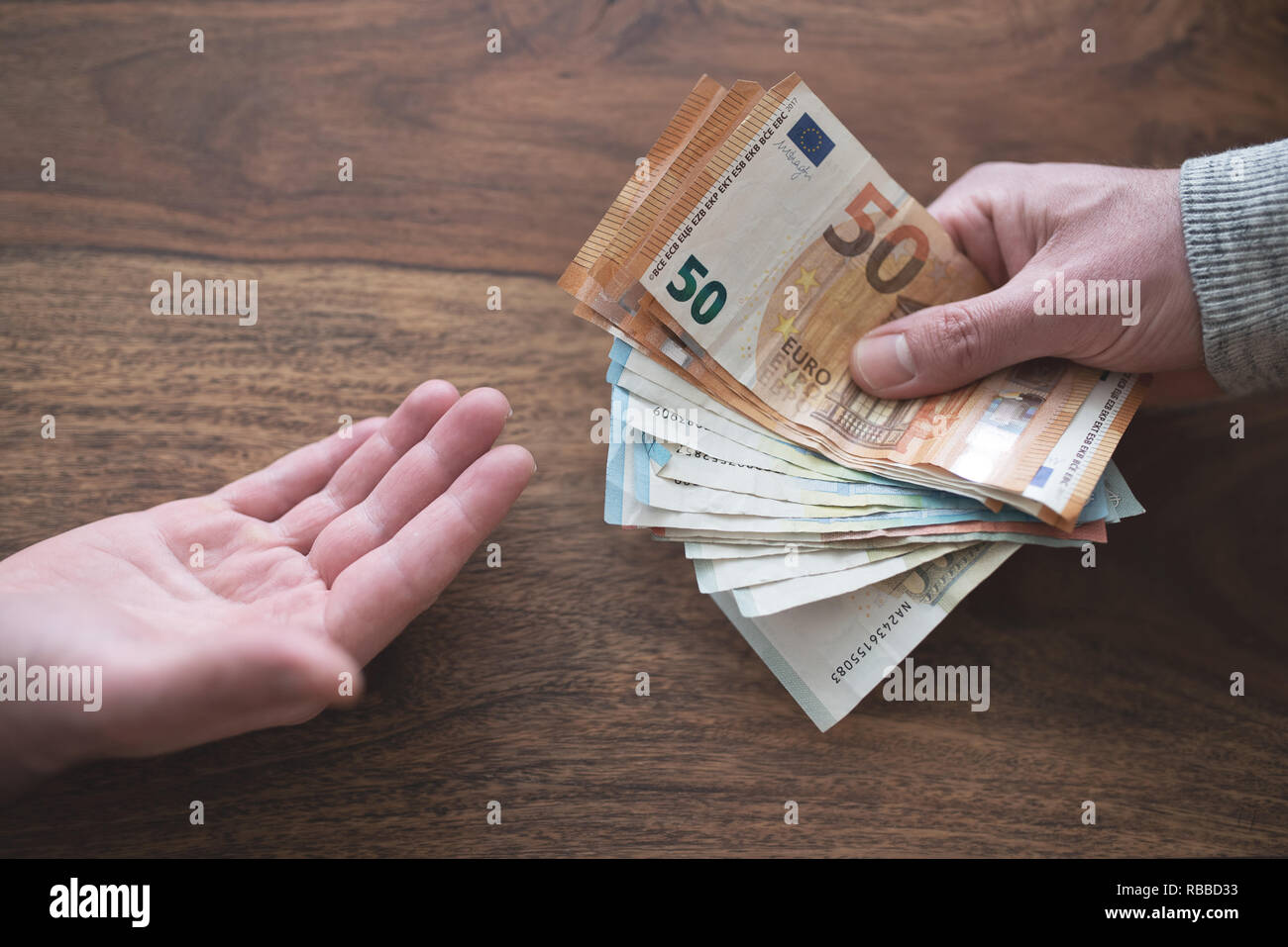 one person handing over cash to another Stock Photo