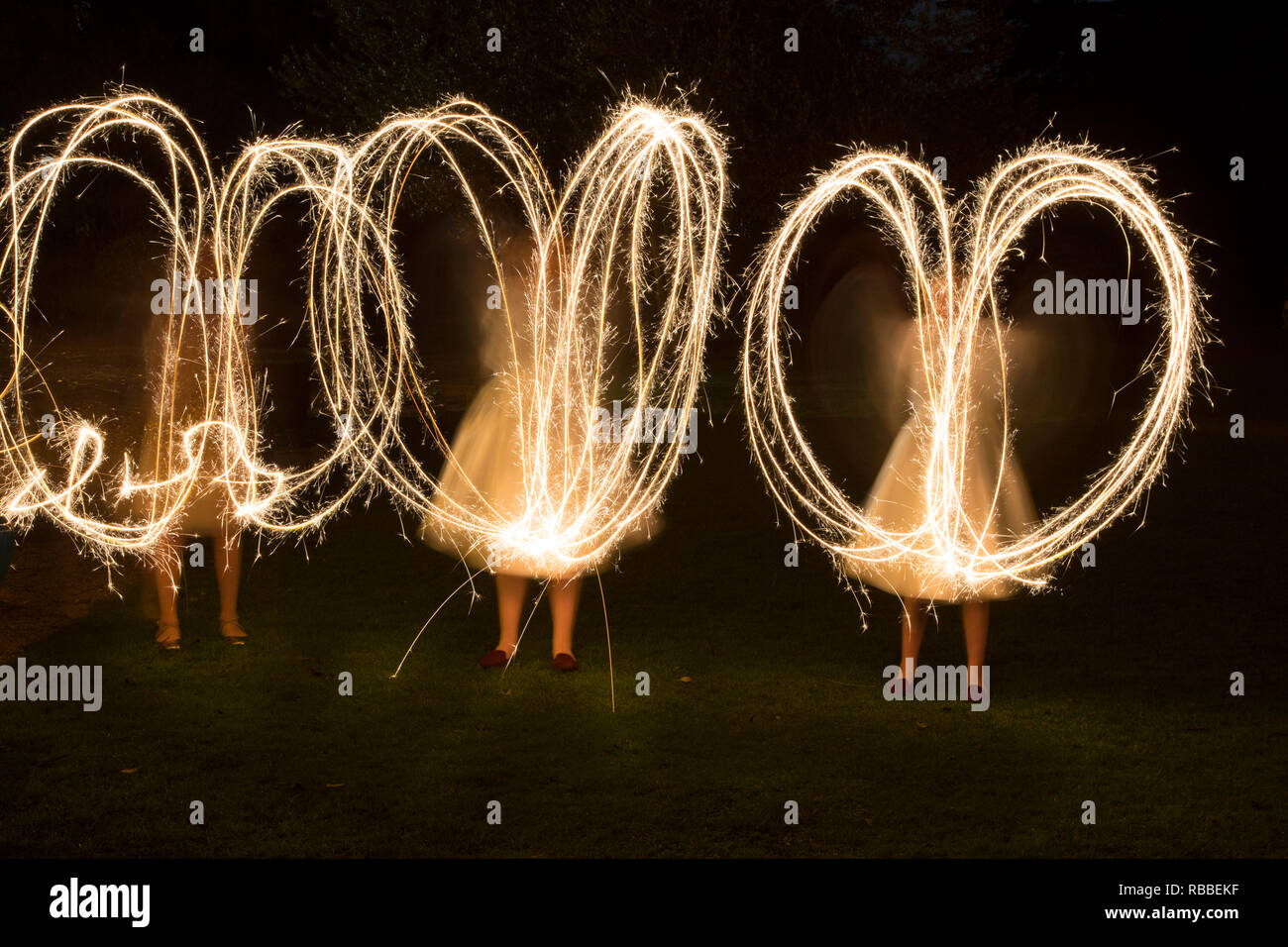 sparklers being whizzed around on a wedding day in the semi dark, by wedding guests, sparkler patterns in the dark, long exposure Stock Photo