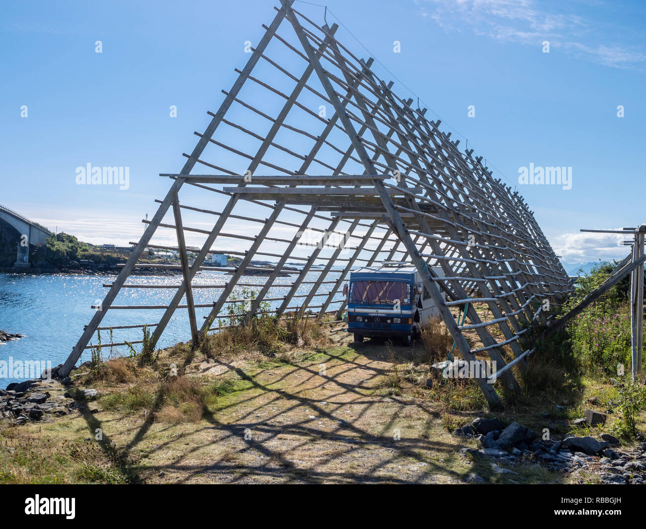 Mobile home,  oldtimer,  parks below wooden drying rack usually used to dry cod in winter, Henningsvaer, Austvagöy, Lofoten, Norway - licence plate di Stock Photo