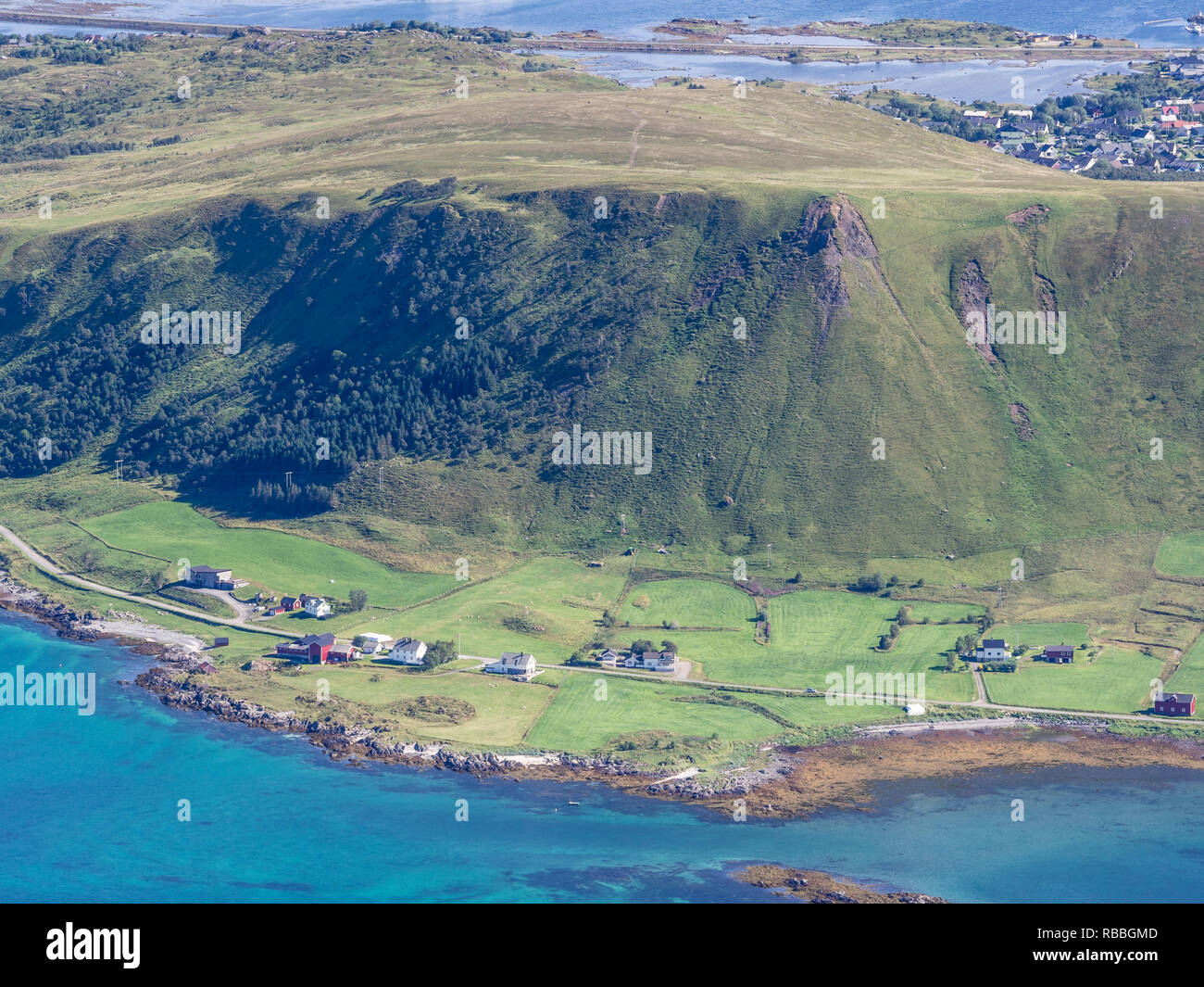View from top of mountain Stornappstind, farms at the shore of west coast of island Vestvagöya, village Gravdal top right,  Lofoten, Norway Stock Photo