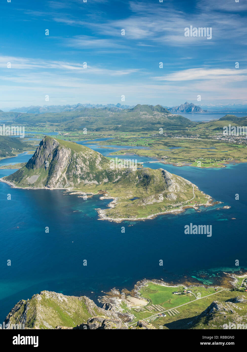 View from top of mountain Stornappstind to island Offersöya, large cliff in the  sea,  mountain Vagekallen in the back, Lofoten, Norway Stock Photo