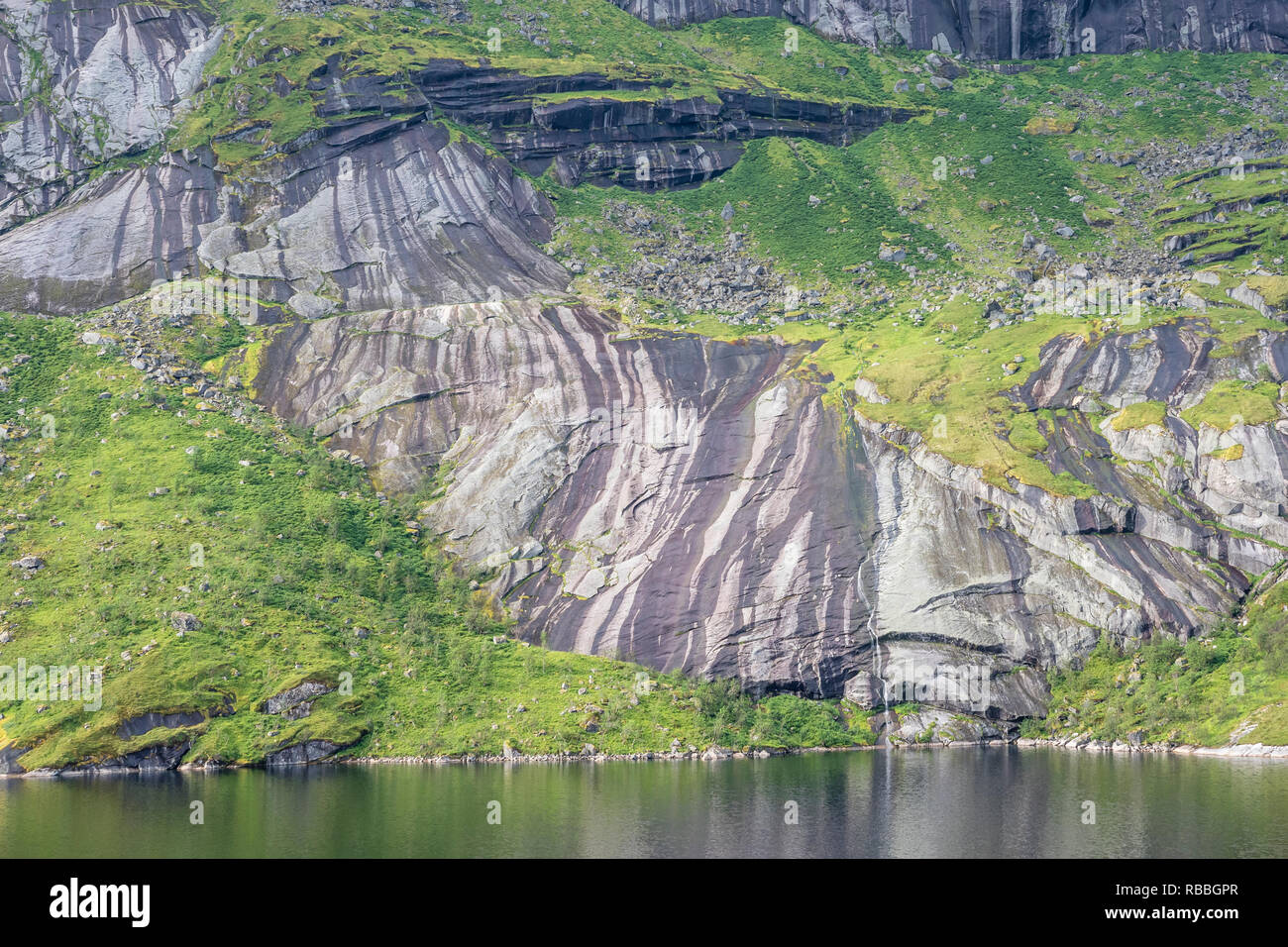 Steep granite cliffs at the road to Nusfjord, narrow single track road ...