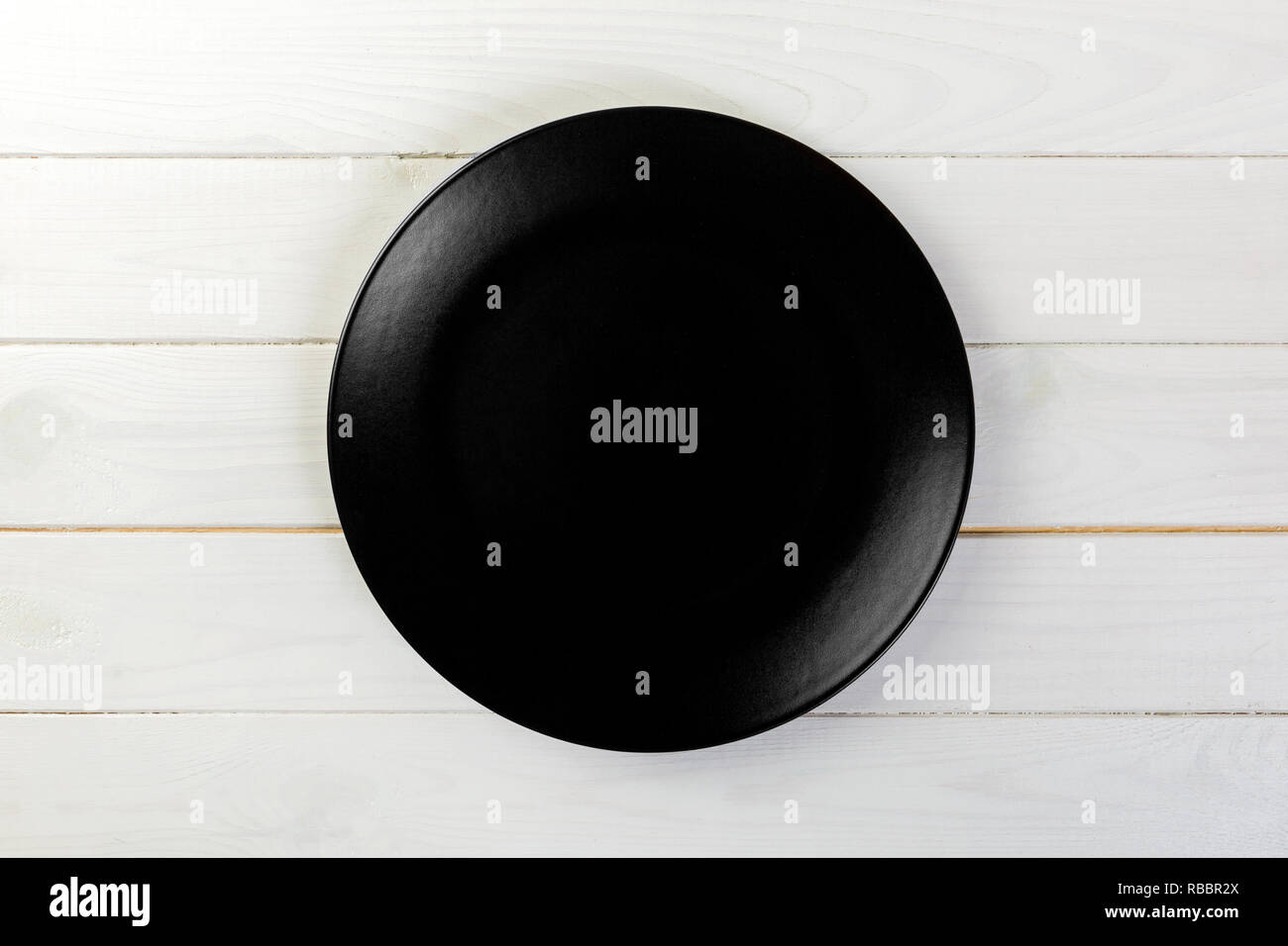 Directy above Empty black matte dish for dinner on white wooden ...