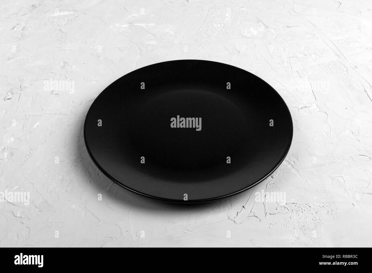 Top view of matte round empty black plate on dark cement background ...