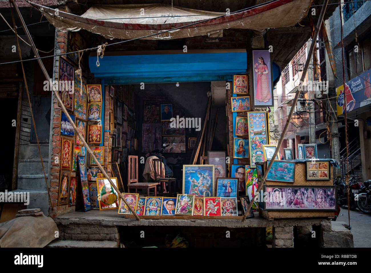 Framing the street: A picture frame shop supplies mostly deities to Khadar's residents enabling spirituality and helping to personalise their homes. Stock Photo
