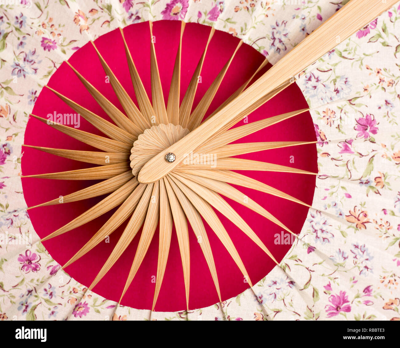 Flat lay. Traditional fan with far eastern motive on a red background close up Stock Photo