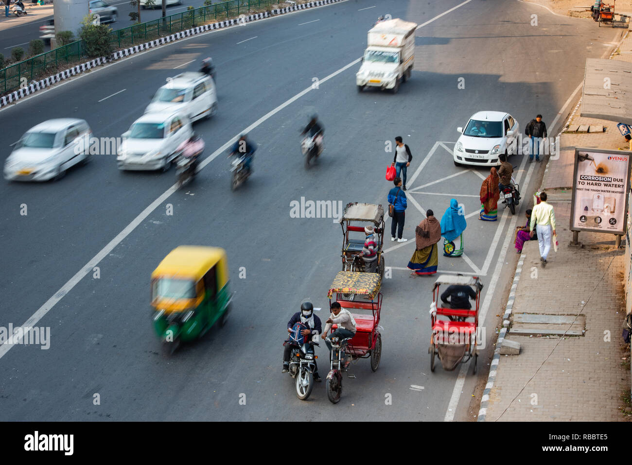 Moving traffic opposite a bus stop near Sarita Vihar Metro Station, New Delhi Stock Photo