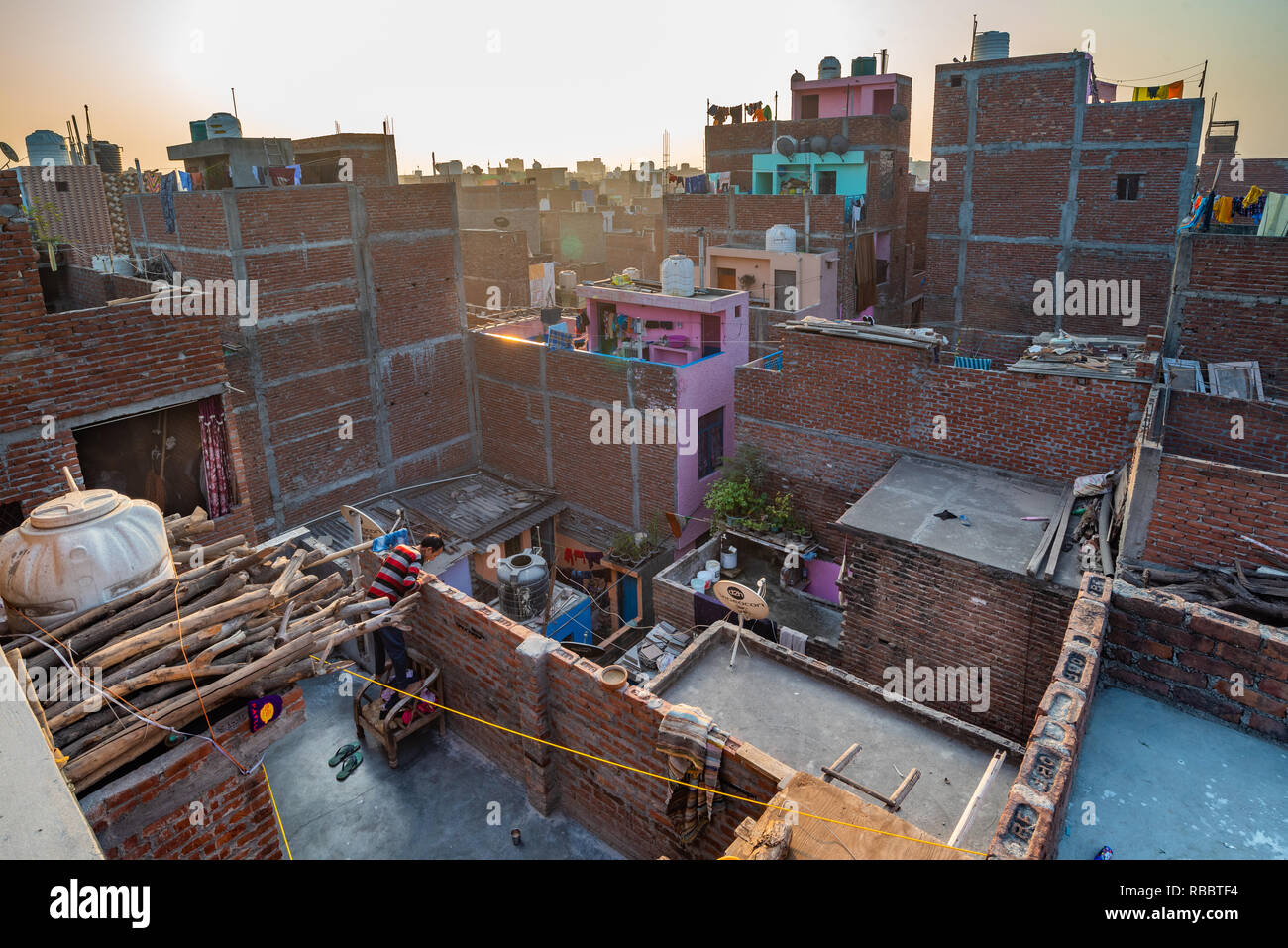 Buildings and roofs in the resettlement New Delhi locality of JJ Colony Madanpur Khadar provide an interesting urban landscape in the morning light Stock Photo