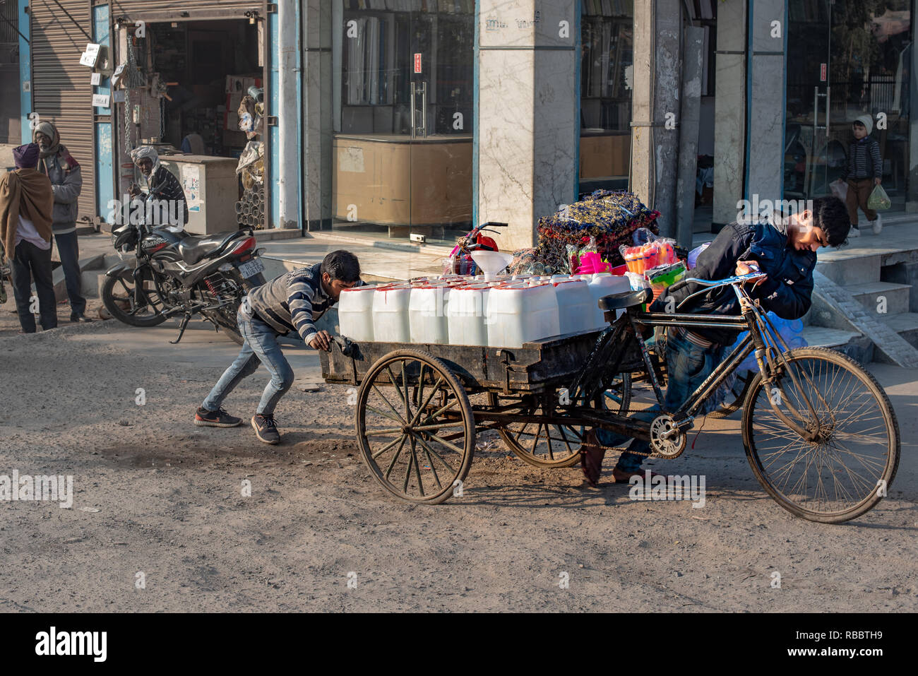 Sharing the burden: Supplying vital drinking water to Khadar's residents in an arduous job (in JJ Colony, Madanpur Khadar, New Delhi) Stock Photo