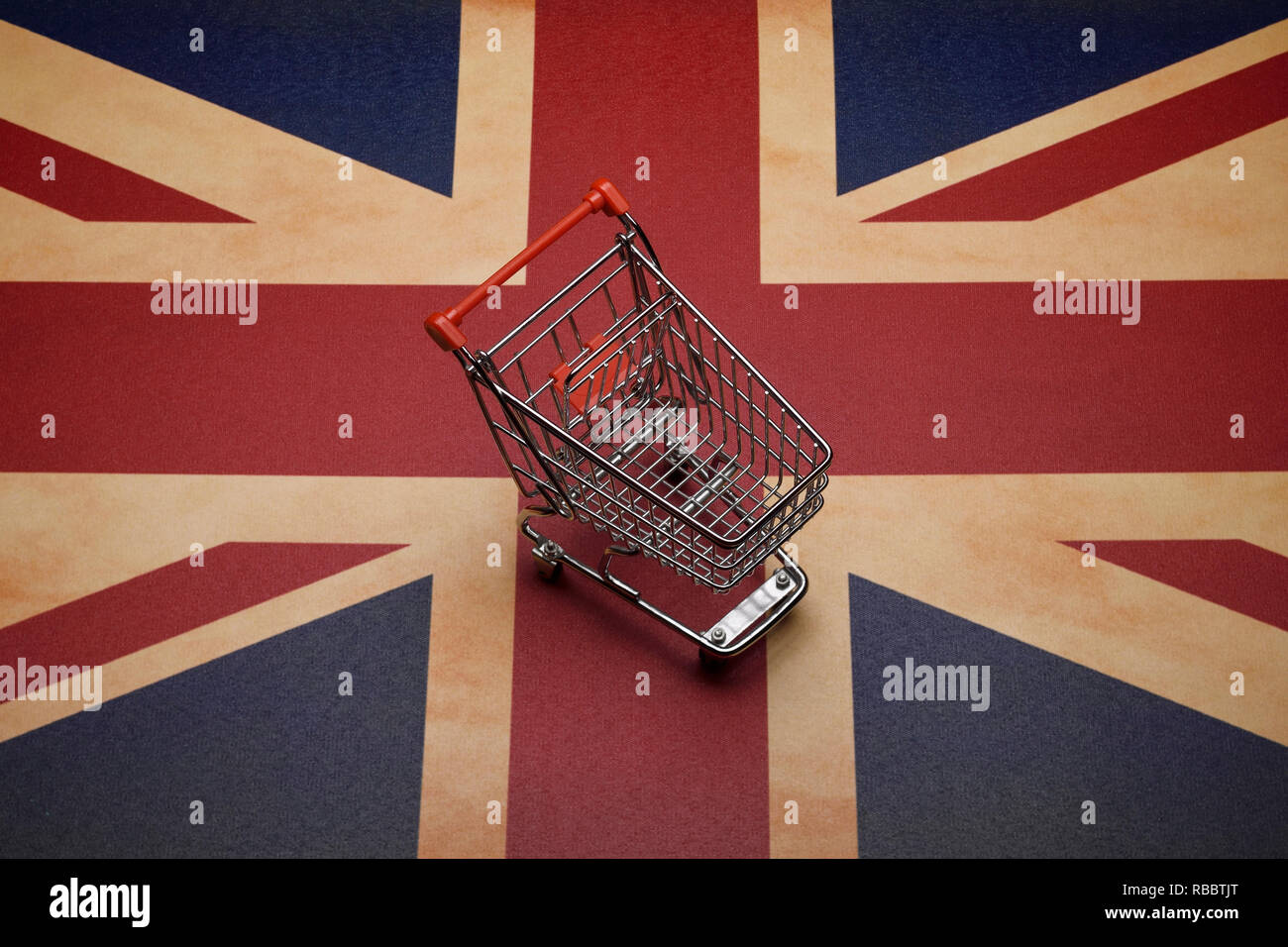 A mini shopping trolley sitting on a Union Jack flag Stock Photo